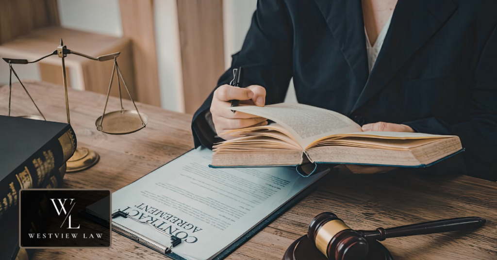 Reviewing the evidence in a retaliation claim Attorney at a desk reading a law book beside a contract agreement, scales of justice and a gavel