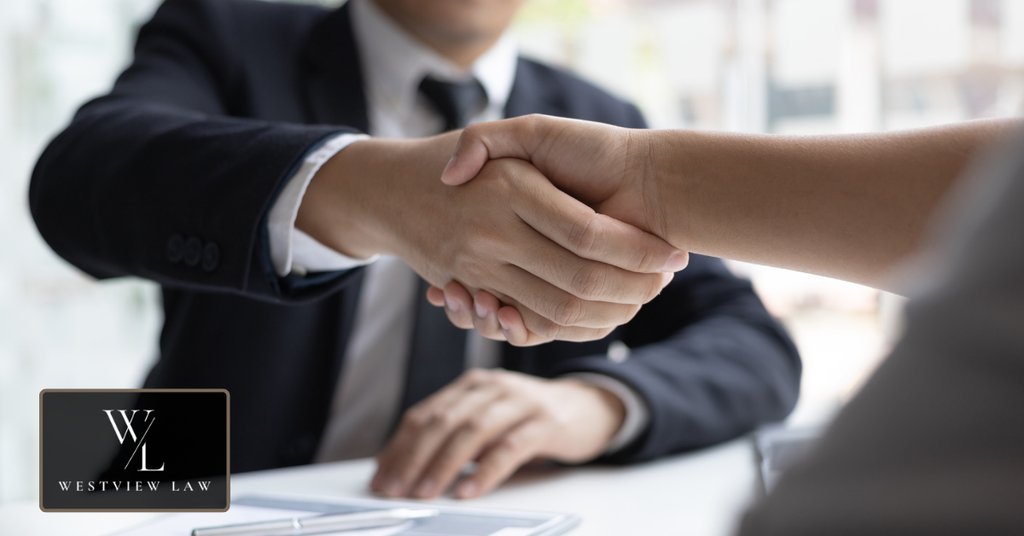 Lawyer shaking hands with a client after negotiating an employment lawsuit settlement.