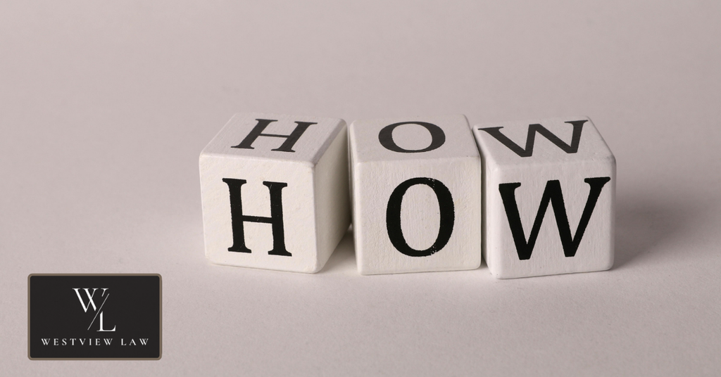 Wooden blocks spelling “HOW,” representing a step-by-step guide to taking legal action against an employer.