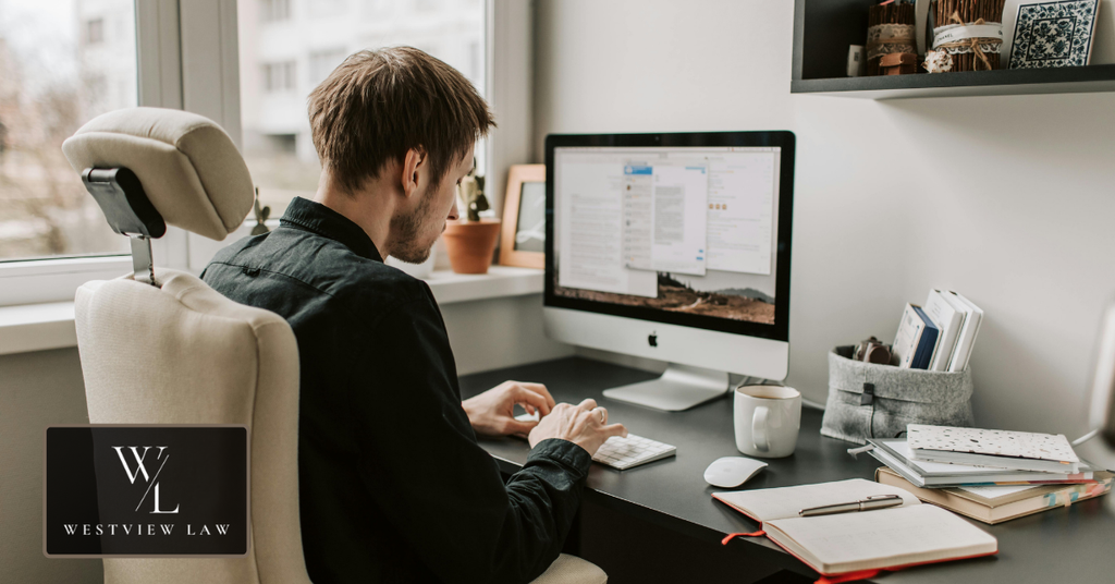 Employee working at a computer in an office, representing returning to work after a workplace injury.